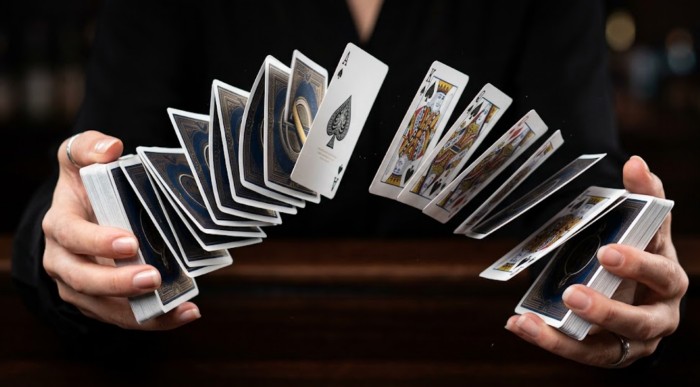 High-speed spring shuffle of premium custom playing cards, highlighting the durability, flexibility, and snappy feel of casino-grade card stock.